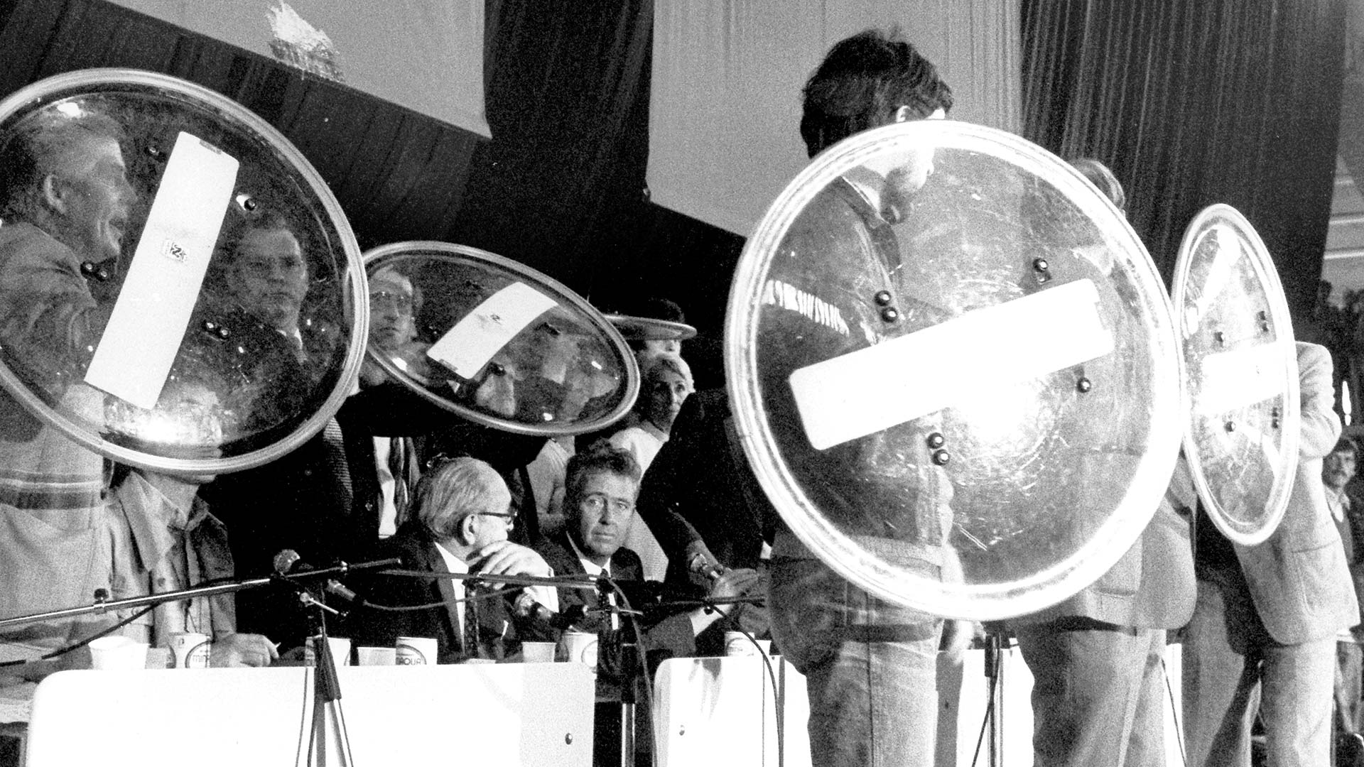 Beim Evangelischen Kirchentag 1981 in Hamburg muss der damalige Verteidigungsminister Hans Apel (Mitte) mit Schilden vor Eierwürfen geschützt werden. Eine kleine Gruppe von Demonstranten unterbrach die Ausführungen von Apel, der die Rüstungsanstrengungen des Westens als notwendig verteidigte.