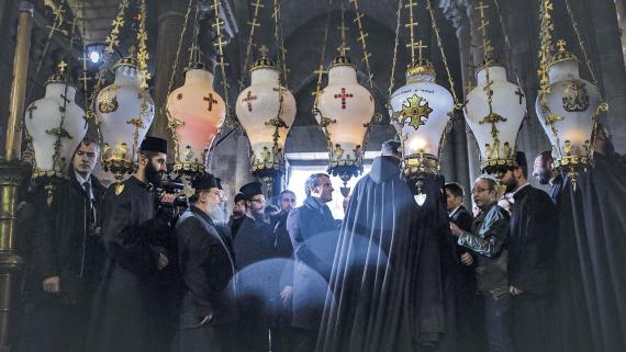 Ohne Berührungsängste, umgeben von Geistlichen und nicht ganz gemäß des Laizitätsprinzips: Frankreichs Präsident Emmanuel Macron in der Grabeskirche von Jerusalem