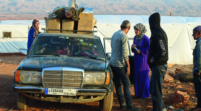 Viele syrische Familien beladen ihre Autos mit ihren Habseligkeiten und fahren über die Grenze des nahen Libanon.